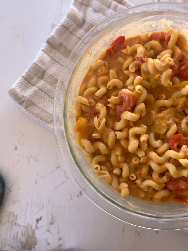 Close-up of chickpea pasta coated in a flavorful hummus and tomato sauce.
